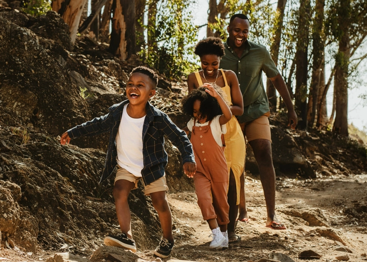 Mom Dad and 2 kids running in the woods